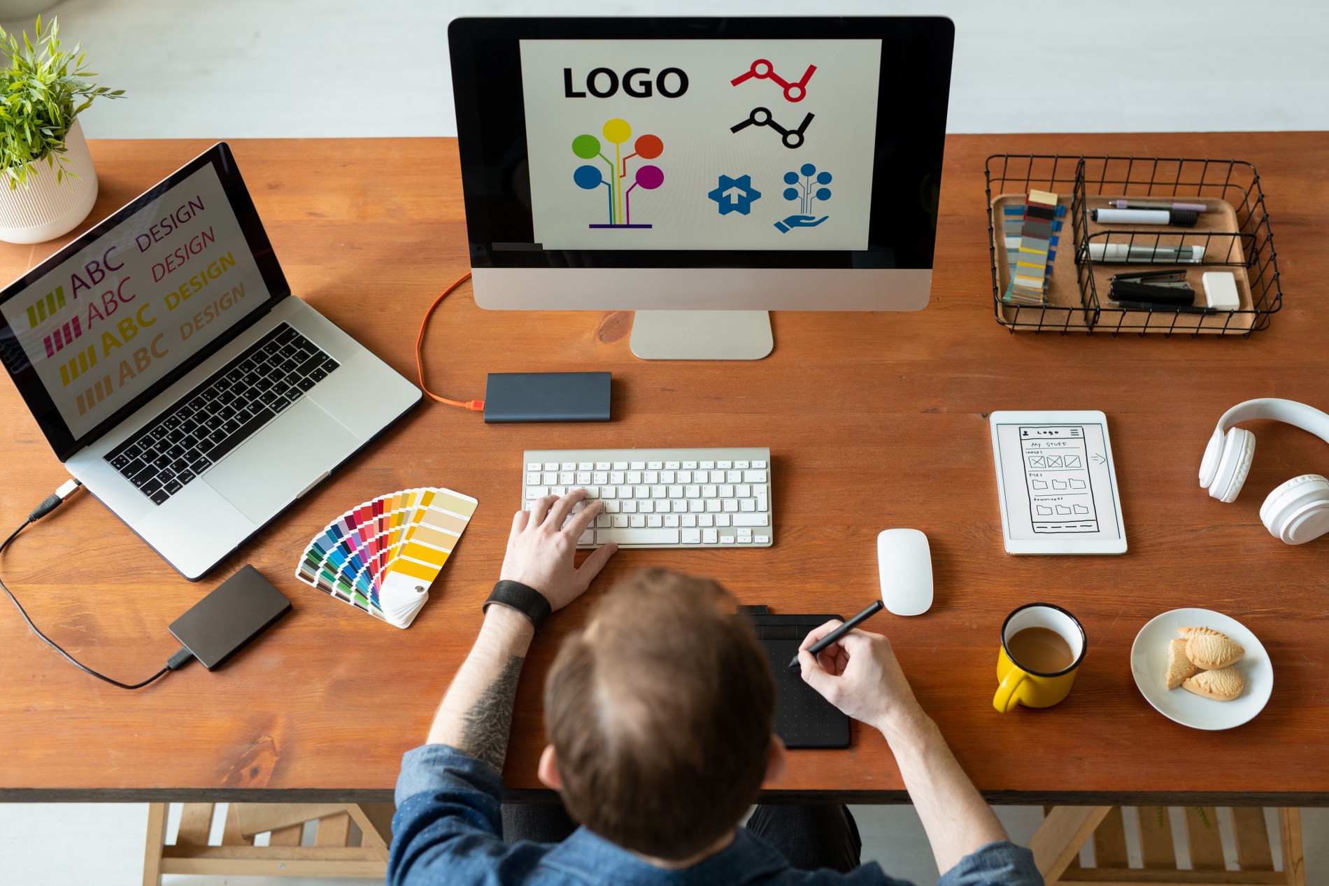 view-logo-designer-sitting-desk-editing-icon-design-using-drawing-pad_1900x1267